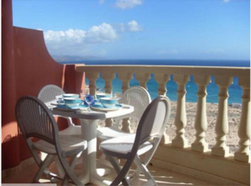 un tavolo e sedie su un balcone con vista sull'oceano di Beach front apartment with stunning ocean views! a Costa Calma