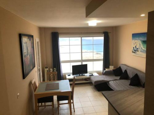 a living room with a couch and a table at Beach front apartment with stunning ocean views! in Costa Calma