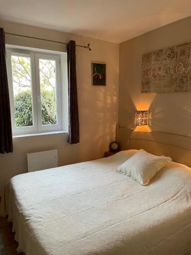 une chambre avec un grand lit blanc avec une fenêtre dans l'établissement Bastidon la Cicada, à Gordes