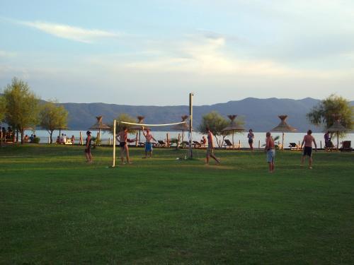 people playing soccer on a grassy field at Lake Shkodra Resort in Grilë