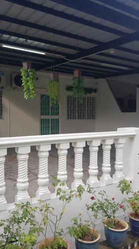 een witte leuning met potplanten op een gebouw bij 12-15 Pax Ssue Silibin Ipoh Guest House-Homestay in Ipoh