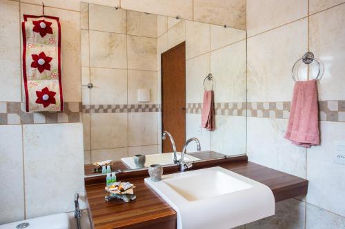 a bathroom with a sink and a mirror at Pousada Beija-Flor in Alto Paraíso de Goiás