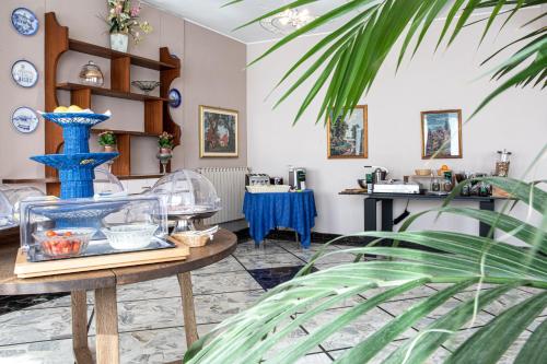 a room with a table with a blue vase on it at Hotel Ariston in Imperia