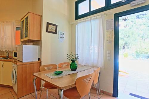 a kitchen with a table and chairs and a kitchen with a window at Kaminaki Dora in Nisaki