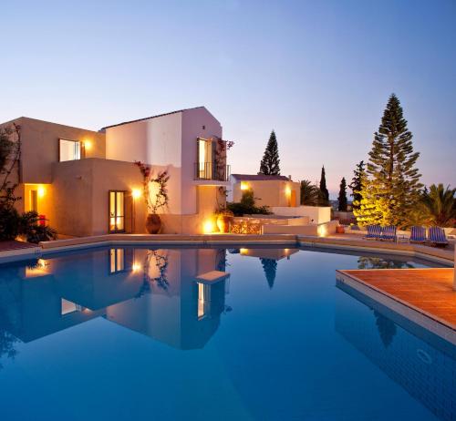 a villa with a swimming pool at night at Galaxy Villas in Hersonissos