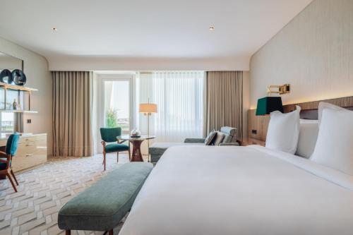 a hotel room with a large bed and a living room at Four Seasons Hotel Ritz Lisbon in Lisbon
