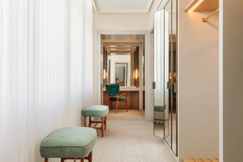 a corridor of a hotel room with chairs and a mirror at Four Seasons Hotel Ritz Lisbon in Lisbon