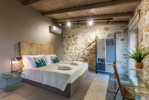 um quarto com uma cama e uma parede de pedra em Evangelia Casa, comfy stay, centrally, with views! em Heraclião