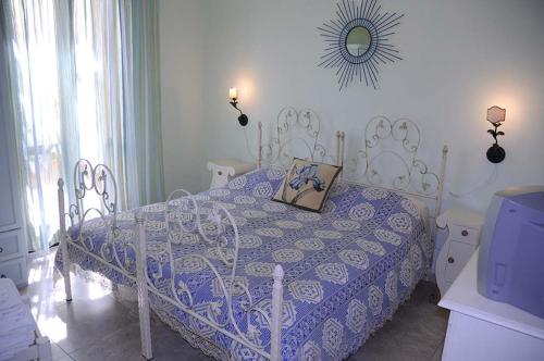 Un dormitorio con una cama azul y blanca y un espejo en AFFITTACAMERE A TRE MINUTI IN SPIAGGIA Il Veliero, en San Vito lo Capo