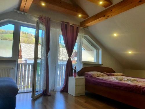 Schlafzimmer mit einem Bett und großen Fenstern in der Unterkunft Apartma DAVID in Zgornje Gorje