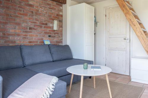 a living room with a blue couch and a table at Lilla Paradiset in Tomelilla