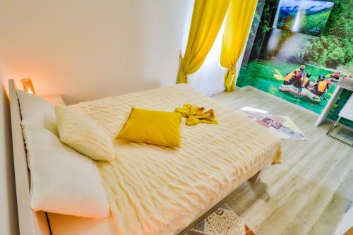 a bed with a yellow bow on it in a room at Simo apartments airport Podgorica in Podgorica