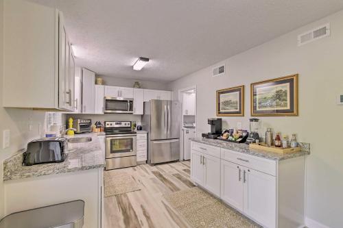 a kitchen with white cabinets and stainless steel appliances at Downtown Southern Pines Townhome with Deck! in Southern Pines