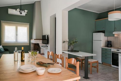 a kitchen with a wooden table and a kitchen with green walls at Emily Villas in Sami
