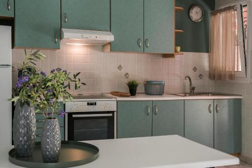 a kitchen with green cabinets and a vase with flowers at Emily Villas in Sami