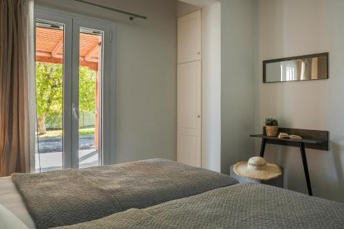 a bedroom with a bed and a sliding glass door at Emily Villas in Sami