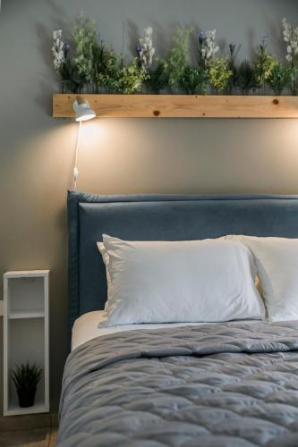 a bed with a blue headboard with plants on it at Emily Villas in Sami