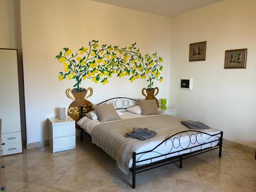a bedroom with a large bed with two vases on the wall at The Lemon Tree in Taormina
