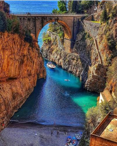 a bridge over a river with boats in the water at Farfalle E Gabbiani in Tramonti