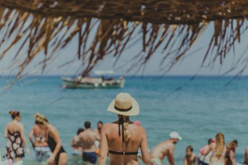 a woman in a hat standing on a beach at Villa Yianna in Nea Mesangala