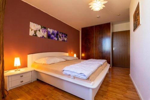 - une chambre avec un lit et une table de nuit avec une lampe dans l'établissement Ferienwohnpark Immenstaad am Bodensee Zwei-Zimmer-Apartment 55 23, à Immenstaad am Bodensee