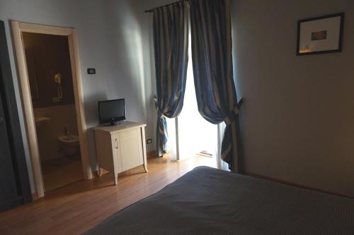 a bedroom with a bed and a television and a window at Hotel Taormina in Rome