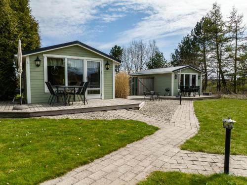 a green house with a table and chairs on a patio at Lilla Paradiset in Tomelilla