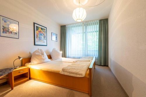 a hotel room with a bed and a window at Ferienwohnpark Immenstaad am Bodensee Zwei-Zimmer-Apartment 55 14 in Immenstaad am Bodensee