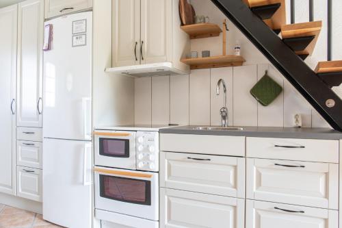 a kitchen with white cabinets and a white refrigerator at Lilla Paradiset in Tomelilla