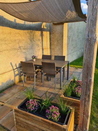 eine Terrasse mit einem Tisch, Stühlen und Blumen in der Unterkunft Ferienwohnung Alte Brennerei in Brösa