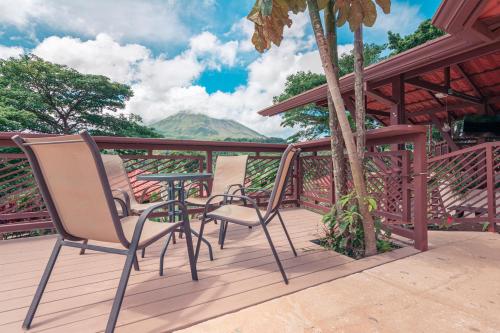 a patio with two chairs and a table on a deck at Miradas Arenal Hotel & Hotsprings in Fortuna