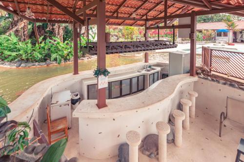 an outdoor bar with a view of the water at Miradas Arenal Hotel & Hotsprings in Fortuna