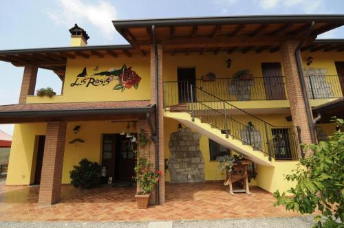 a large yellow building with a balcony and a staircase at Agriturismo Lis Rosis in Medea