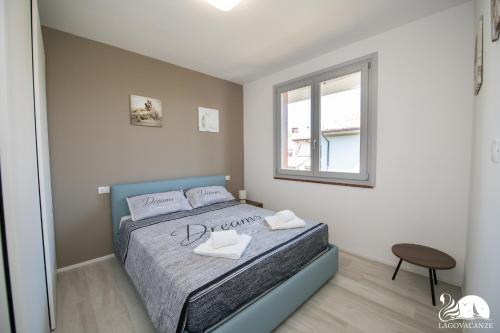 een slaapkamer met een bed en een raam bij Villa Liliana - App. 06 in Sirmione