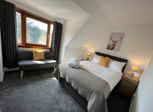 a bedroom with a bed and a chair and a window at The Thistle Guesthouse in Portree