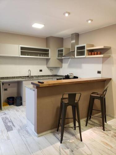 una cucina con due sgabelli e un bancone in una stanza di Departamentos de Raffi a Villa Constitución