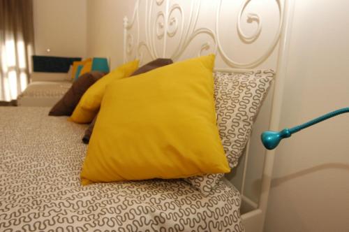 a bed with yellow pillows on top of it at Il girasole in Dervio