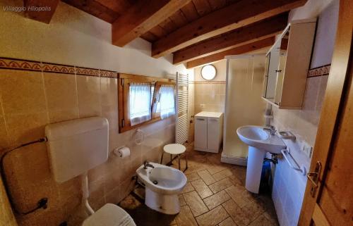 a bathroom with a white toilet and a sink at Villaggio Heliopolis in Manerba del Garda