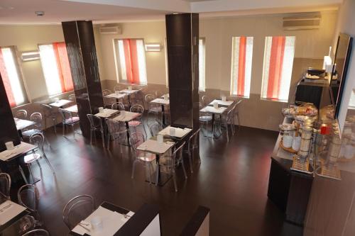 a dining room with tables and chairs and windows at Hotel Mariano in Rome