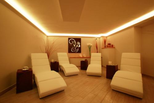 a waiting room with white chairs and a table at Colle Galli in Acquapendente