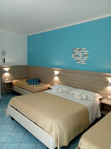 a hotel room with two beds and a blue wall at Borgo 800 in San Nicola Arcella