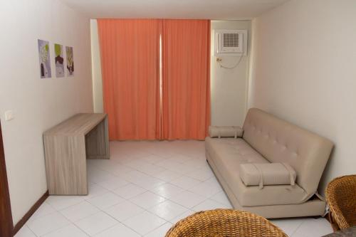 a living room with a couch and an orange door at VOA Ambassador Flat in João Pessoa