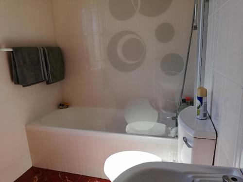 a bathroom with a tub and a toilet and a sink at Nagua bay in Gordonʼs Bay