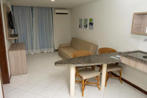 a living room with a couch and a table and chairs at VOA Ambassador Flat in João Pessoa