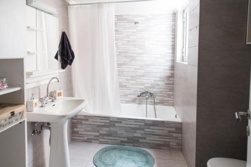 a bathroom with a bath tub and a sink at Malvina's Dream - Comfort and style-Central Aigio in Aigio