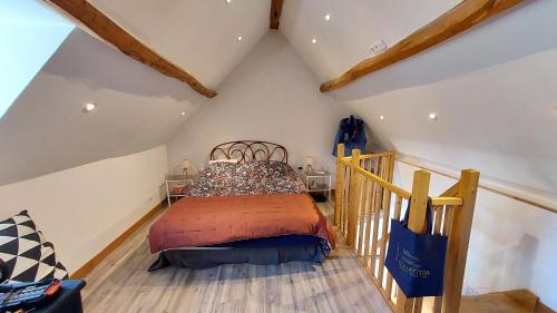 a bedroom with a bed in a attic at La maison aux oiseaux in Heudreville-sur-Eure