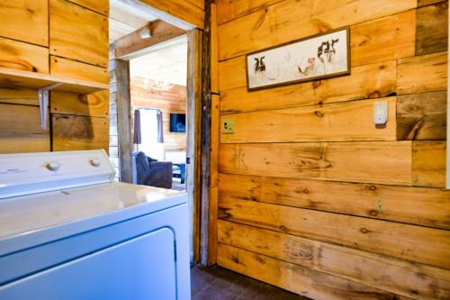 eine Waschküche mit Holzwänden sowie einer Waschmaschine und einem Trockner in der Unterkunft Cottage on the Creek in Salem