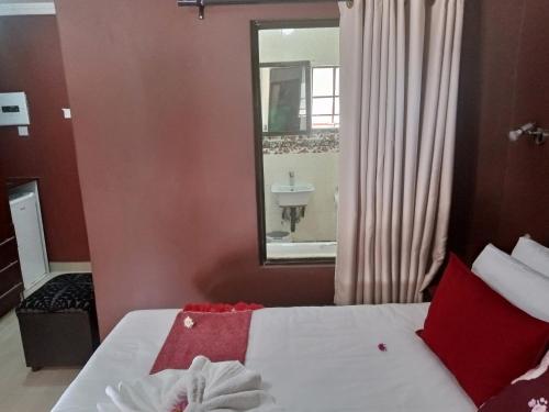 a bedroom with a bed with a mirror and a sink at Impovu Guest House in Kasane