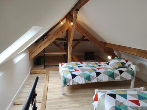 Cette chambre mansardée comprend un lit et un escalier. dans l'établissement duplex appartement 70m2 atypique au cœur du Mans, au Mans
