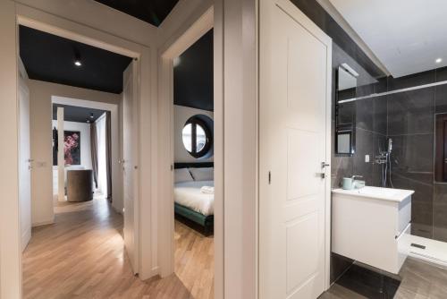bagno con porta bianca che conduce a una camera da letto di Brera Premium Apartment near Duomo Wifi a Milano